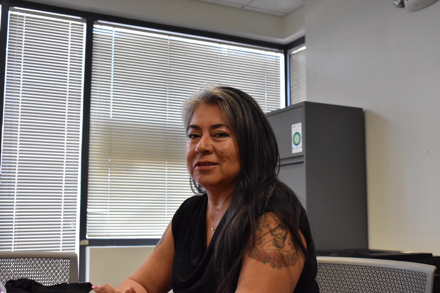 Woman sitting in an office building and smiling.